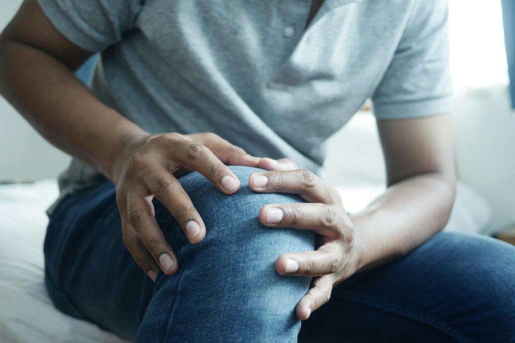 Patient fasst sich an sein schmerzendes Knie